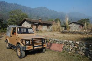 a brown truck parked in front of a stone wall at Wild Brook in Rishīkesh