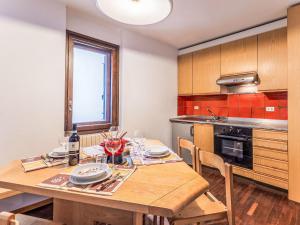 a kitchen with a wooden table with wine glasses at Apartment Fondue by Interhome in Madesimo +11 photos