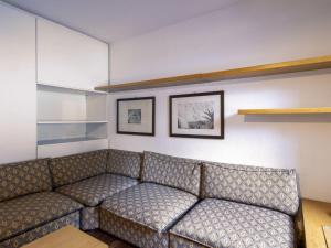 a couch in a room with two pictures on the wall at Apartment Fondue by Interhome in Madesimo