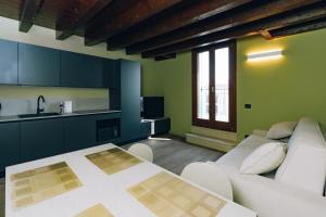 a living room with a table and a kitchen at Legnago Suite Apartments in Legnago