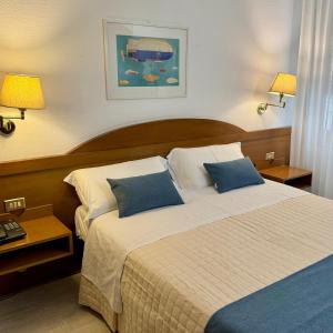 a bedroom with a large bed with two blue pillows at Hotel Arcadia in Macerata +160 photos