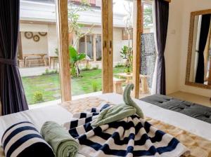 a bedroom with a bed and a large window at Ramaiin guest house in Nusa Dua +33 photos