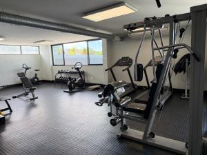 a gym with several tread machines in a room at Keddy J Apartments in Windhoek