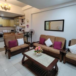 a living room with two couches and a table at RIVERBANK SUITE with riverfront mountain DUN view in Kuching