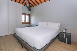 a bedroom with a large white bed and a wooden floor at Legnago Suite Apartments in Legnago