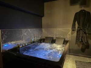 a jacuzzi tub in a room with a jacket at Ruby Room in Mâcon