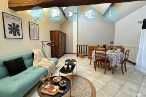 a living room with a blue couch and a dining room at Station Studio - Proche RER A - Wifi in Noisy-le-Grand