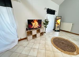 a living room with a tv on a stand with a fire at Station Studio - Proche RER A - Wifi in Noisy-le-Grand