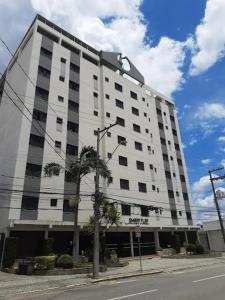 a large white building on the side of a street at Smart Flat Apart in Mogi das Cruzes