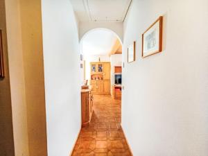 a hallway leading to a kitchen with an archway at Apartment Casa Dalpi by Interhome in Predazzo