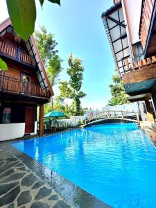 a large blue swimming pool next to a building at KeJogja Homestay in Grigak