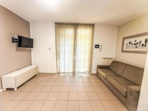 a living room with a couch and a television at Holiday Home Veranda-2 by Interhome in Rosapineta