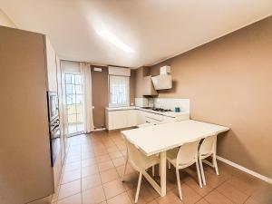 a small kitchen with a white table and chairs at Holiday Home Veranda-2 by Interhome in Rosapineta