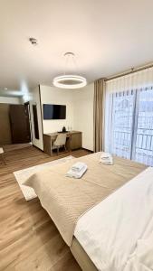 a bedroom with a large bed with two towels on it at Continental SPA in Palyanytsya