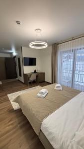a bedroom with a large bed with two towels on it at Continental SPA in Palyanytsya