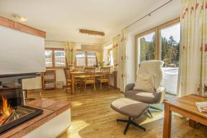 a living room with a fireplace and a chair and a table at Ferienwohnung Bergblick in Filzmoos