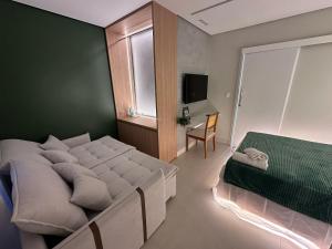 a bedroom with a bed and a table and a window at Apartamento com suíte e sala com ar-condicionado in Barreiras