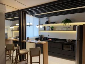 a kitchen with a counter and some chairs in it at Apartamento com suíte e sala com ar-condicionado in Barreiras