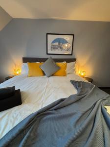 a bedroom with a large white bed with yellow pillows at Vestley Banks in Orkney