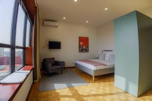 a bedroom with a bed and a chair and a television at Casa de Cristal by Oporto Soul in Porto