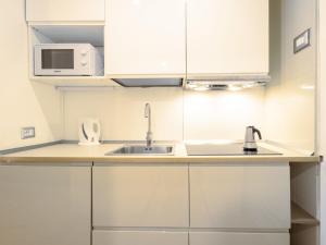 a kitchen with white cabinets and a sink at Studio Studio T by Interhome in Bormio +24 photos
