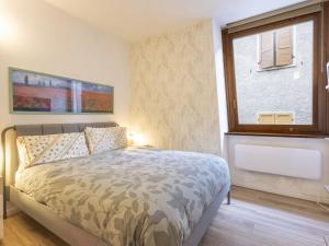 a bedroom with a large bed and a window at Studio Studio T by Interhome in Bormio