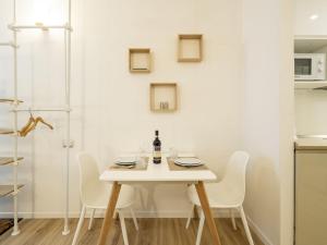 a white dining room with a white table and chairs at Studio Studio T by Interhome in Bormio