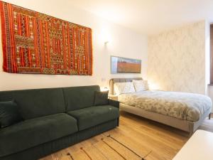 a living room with a couch and a bed at Studio Studio T by Interhome in Bormio
