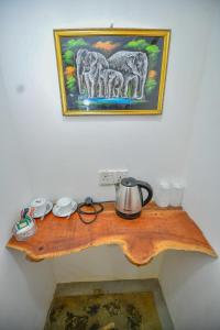 a wooden table with a tea kettle on top of it at Jungle View River Camping in Udawalawe