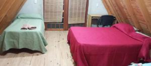 a bedroom with a bed with a pink blanket and a chair at Cabaña don Cencio in San Pedro +32 photos