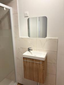 a bathroom with a sink and a mirror at Super appartement in Malesherbes