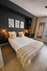 a bedroom with a large white bed with two windows at CK Suite & Spa - Jacuzzi Privatif - Reims in Reims