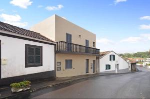 a street view of a house with a balcony at Capelas Pdl Apartment in Ponta Delgada