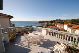 balcón con mesa, sillas y vistas al océano en Villa Fiorella, en Castiglioncello