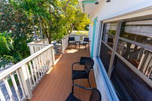 a porch with two chairs and tables on it at Cindy Villa in Key Largo