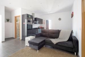 a living room with a couch and a kitchen at Capelas Pdl Apartment in Ponta Delgada