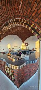 a living room with a brick wall and a kitchen at Habibi Nubian Guest House-Nubian Hospitality in Aswan