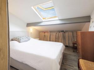 a bedroom with a white bed and a skylight at Apartment Barasteguia by Interhome in Ciboure