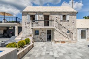 a stone house with a balcony and a patio at Authentic Dalmatian stone villa in Selca