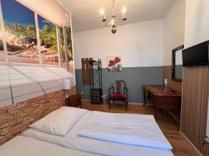 a bedroom with a bed and a desk and a television at Hotel Galleria in Munich