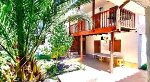 a house with a balcony and a bench in a yard at The Green Corner Urubamba in Urubamba