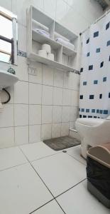 a white tiled bathroom with a toilet and a window at The Green Corner Urubamba in Urubamba +42 photos