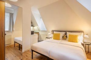a bedroom with a large white bed with yellow pillows at Pytloun Self Check-in Hotel Liberec in Liberec