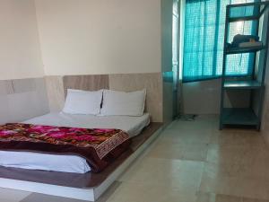 a bedroom with a bed and a window at Hotel Sukhdev in Nawalgarh
