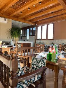 a dining room with wooden tables and benches with bottles on them at Shams Boutique Hotel in Bukhara