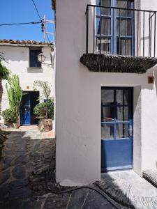 a white building with a blue door at Apartment at Cadaqués Church in Cadaqués +3 photos