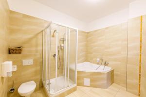 a bathroom with a shower and a toilet and a sink at Eagle Hotel in Šamorín