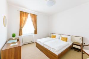 a white bedroom with a bed and a window at Eagle Hotel in Šamorín