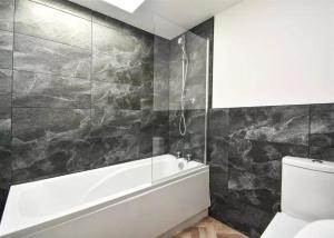 a bathroom with a bath tub and a toilet at Glams luxury home in Wolverhampton +29 photos
