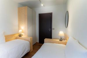 a bedroom with two beds and a black door at Casa vacanza Garcia in Paluzza